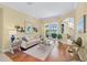 Bright living room featuring hardwood floors, neutral paint, stylish decor, and sliding glass doors to the screened lanai at 518 Luminary Blvd, Osprey, FL 34229