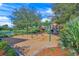 Community playground with swings, slides, and play structures, set against a backdrop of mature trees at 518 Luminary Blvd, Osprey, FL 34229
