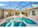 Inviting screened-in pool area featuring a hot tub and patio space, perfect for entertaining at 518 Luminary Blvd, Osprey, FL 34229