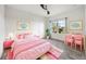Charming bedroom with pink accents, a work desk, and a large window at 6318 Anise Dr, Sarasota, FL 34238
