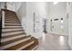 Bright foyer with staircase, tile flooring, and modern art at 6318 Anise Dr, Sarasota, FL 34238