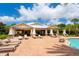 A pool clubhouse with brick paver patio, mature palms and ample lounge seating for residents at 6318 Anise Dr, Sarasota, FL 34238