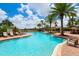Inviting community pool featuring ample lounge seating, mature palms, and a splash pad for hours of fun at 6318 Anise Dr, Sarasota, FL 34238