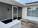 Screened-in porch with gray walls and a white door, offering a peaceful entryway at 8026 Barberry Dr, Port Richey, FL 34668