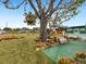 Lush backyard features a swing, unique hanging plant, and well-manicured lawn, perfect for relaxation at 1000 Dartmouth Dr, Bradenton, FL 34207