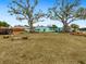Expansive backyard featuring a fire pit, seating, and mature trees, creating an inviting outdoor space at 1000 Dartmouth Dr, Bradenton, FL 34207