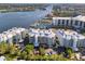 Aerial view of waterfront community with 3-story buildings, parking, and marina at 1260 Dolphin Bay Way # 402, Sarasota, FL 34242