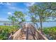 Wooden dock leading to the water with trees at 1260 Dolphin Bay Way # 402, Sarasota, FL 34242