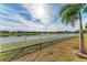 Landscaped backyard with lake view and white vinyl fence at 12848 24Th Street E Cir, Parrish, FL 34219