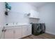 Functional laundry room with washer, dryer, and ample storage at 14307 Skipping Stone Loop, Parrish, FL 34219