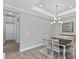 Bright dining room featuring a dark wood table, white chairs, and a chandelier at 15619 Sacile Ln, Lakewood Ranch, FL 34211