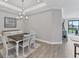 Elegant dining room with chandelier, dark wood table and white chairs at 15619 Sacile Ln, Lakewood Ranch, FL 34211