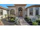 Charming stone and stucco home with a grand entrance, lush landscaping, and a paver walkway at 1609 Palm View Rd, Sarasota, FL 34240