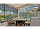 Beautiful screened-in lanai with dining area overlooking the pool and lush backyard at 1609 Palm View Rd, Sarasota, FL 34240