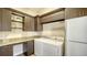 Convenient laundry room with granite counters, built-in cabinets, washer and dryer, and extra refrigerator at 1609 Palm View Rd, Sarasota, FL 34240