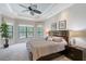 Spacious main bedroom featuring large windows, tray ceilings, and a ceiling fan for natural light and comfort at 1609 Palm View Rd, Sarasota, FL 34240