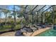 Refreshing backyard pool with screened enclosure and multiple lounge chairs at 1609 Palm View Rd, Sarasota, FL 34240