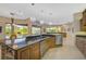 This gourmet kitchen has wood cabinets, granite countertops, an island and a pool view at 2123 Calusa Lakes Blvd, Nokomis, FL 34275