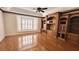 Empty living room with hardwood floors, a ceiling fan, and built-in shelving at 2123 Calusa Lakes Blvd, Nokomis, FL 34275