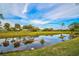 Scenic view of a tranquil pond reflecting the blue sky and surrounding trees, enhancing the property's natural beauty at 2123 Calusa Lakes Blvd, Nokomis, FL 34275