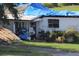 Exterior of a home with blue tarps, exposed lumber, and overgrown vegetation at 2815 Us-41 N, Palmetto, FL 34221