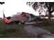 Damaged home with exposed roof structure and an American flag at 2815 Us-41 N, Palmetto, FL 34221