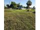 Outdoor shot of a property for sale, featuring a distressed home with a tarp-covered roof and a large grassy lot at 2815 Us-41 N, Palmetto, FL 34221