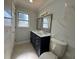 Bright bathroom featuring a double sink vanity, marbled walls and a toilet at 2820 Wood St, Sarasota, FL 34237