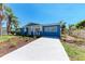 Well-maintained blue home with a charming front porch, landscaped garden, and a new driveway at 2820 Wood St, Sarasota, FL 34237