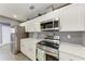 Modern kitchen featuring white cabinets, stainless steel appliances, and stylish gray tile flooring at 2820 Wood St, Sarasota, FL 34237