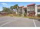 Condo exterior with red tile roof, screened balconies, lush landscaping, and ample parking on a sunny day at 3267 Beneva Rd # 201, Sarasota, FL 34232