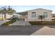 Front view of a manufactured home with carport and landscaped yard at 3386 Oakwood N Blvd, Sarasota, FL 34237