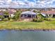 Aerial view of a home featuring a screened-in patio and large, landscaped backyard near a lake at 4779 Pastel Ct, Sarasota, FL 34240