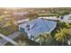 An aerial view showcases a modern home with a screened-in lanai, set by a tranquil lake at 4779 Pastel Ct, Sarasota, FL 34240