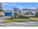 Beautiful home exterior with a blue garage door, well-manicured landscaping, and a bright blue sky at 4779 Pastel Ct, Sarasota, FL 34240