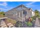 Exterior view of a home with a screened patio, complemented by lush landscaping and stone pathway at 4779 Pastel Ct, Sarasota, FL 34240