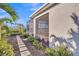 A beautifully landscaped yard leads to a home with a screened-in patio and serene lake view at 4779 Pastel Ct, Sarasota, FL 34240