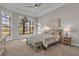 Serene main bedroom with a tray ceiling, large windows, and a cozy seating bench at the foot of the bed at 4779 Pastel Ct, Sarasota, FL 34240