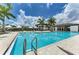 Resort-style pool with palm trees, lounge seating, and a building with a covered outdoor area at 4779 Pastel Ct, Sarasota, FL 34240