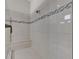 A spacious walk-in shower features a built-in bench, decorative accent tiles and a rainfall shower head at 4779 Pastel Ct, Sarasota, FL 34240