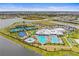 Aerial view of the community clubhouse featuring a pool, tennis courts, playground, and parking at 5107 Coral Reef Way, Bradenton, FL 34211