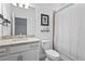 Bright bathroom featuring a granite vanity top, white cabinets, and a shower with a linen curtain at 5107 Coral Reef Way, Bradenton, FL 34211