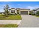 Single-story home featuring a well-kept lawn, a two-car garage, and a welcoming entrance at 5107 Coral Reef Way, Bradenton, FL 34211
