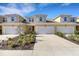 Townhome featuring an attached garage, new landscaping, and a charming red front door at 5658 Silverbridge Trl, Bradenton, FL 34211