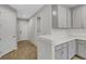 Hallway view of kitchen with quartz countertops and stainless steel appliances leading to laundry room at 5658 Silverbridge Trl, Bradenton, FL 34211