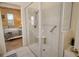 Bathroom shower with tile walls, glass surround, and a bench. Primary bedroom in background at 6504 Copper Ridge Trl, Bradenton, FL 34201