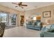 Spacious living area with a teal couch, tiled floors, and sliding doors to the patio at 6504 Copper Ridge Trl, Bradenton, FL 34201