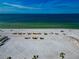 Aerial view of beach with yellow umbrellas and clear water at 915 Seaside Dr # 604, Sarasota, FL 34242