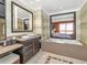 Upscale bathroom with soaking tub, double vanity, and view of bedroom at 915 Seaside Dr # 604, Sarasota, FL 34242