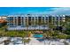 Beachfront resort featuring a pool and palm trees with beach access at 915 Seaside Dr # 604, Sarasota, FL 34242